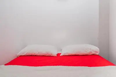 two pillows on a bed with a red and white blanket at Apartman Glendza in Ulcinj