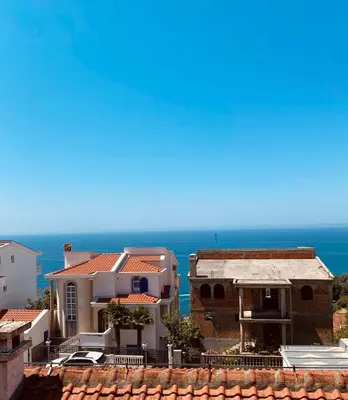 a view of a house with the ocean in the background at Apartman Glendza in Ulcinj