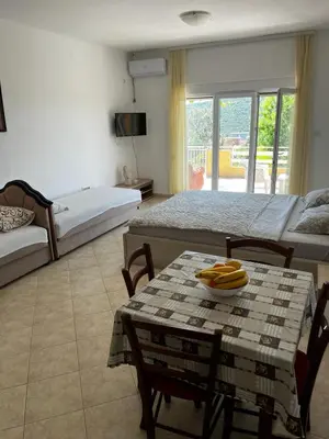 a room with two beds and a table with bananas on it at Apartman Perić in Bigovo