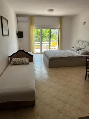 a bedroom with two beds and a tiled floor at Apartman Perić in Bigovo