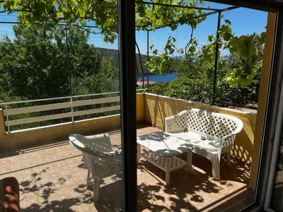 a patio with a table and chairs on a balcony at Apartman Perić in Bigovo