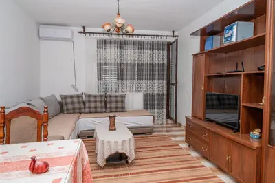 a living room with a couch and a tv at Glendza Apartman in Ulcinj