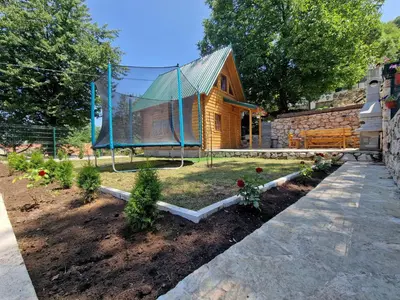 a garden with a wooden house and some flowers at Brvnara RIĆKI in Cetinje