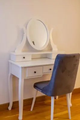 a white desk with a mirror and a blue chair at Apartments RONDO in Ulcinj