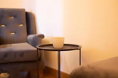 a table with a cup on it next to a chair at Apartments RONDO in Ulcinj