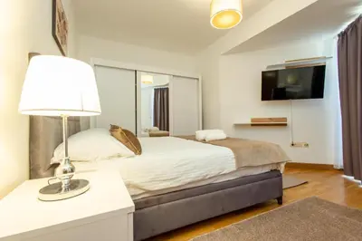 a bedroom with a bed with a lamp and a tv at Apartments RONDO in Ulcinj