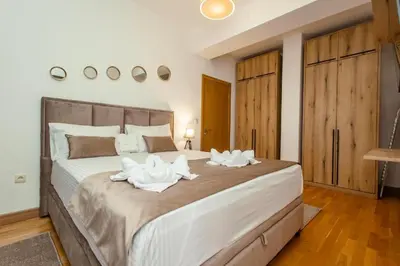 a bedroom with a large bed with white towels on it at Apartments RONDO in Ulcinj
