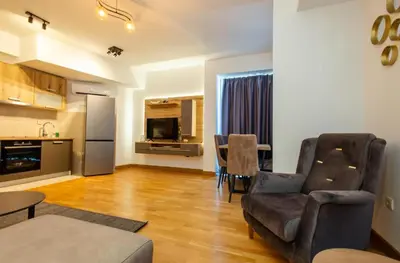 a living room with a couch and a table and a kitchen at Apartments RONDO in Ulcinj