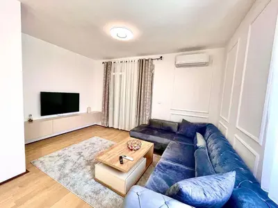 a living room with a blue couch and a table at BS Apartman in Podgorica