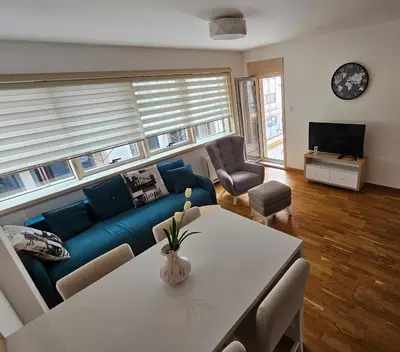 a living room with a blue couch and a table at Apartman Ema in Budva