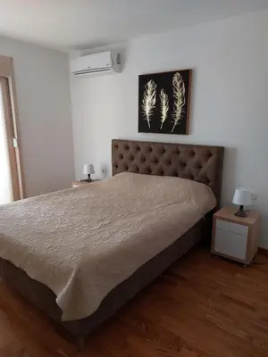 a bedroom with a large bed and two night stands at Apartman Ema in Budva