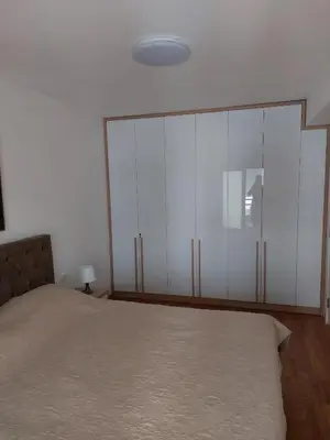 a bedroom with a bed and white cabinets at Apartman Ema in Budva