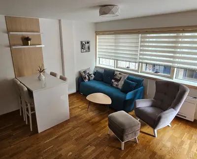 a living room with a blue couch and a table at Apartman Ema in Budva