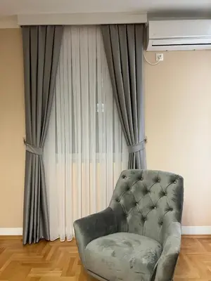 a couch sitting in front of a window with curtains at Two bedroom lux apartment in Budva
