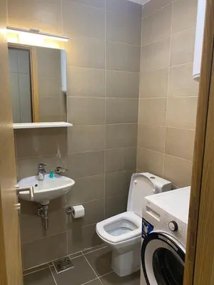 a bathroom with a toilet and a sink and a washing machine at Two bedroom lux apartment in Budva