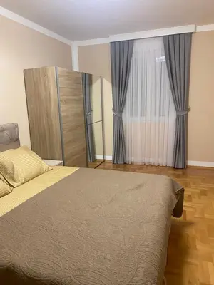 a bedroom with a bed and a window with curtains at Two bedroom lux apartment in Budva