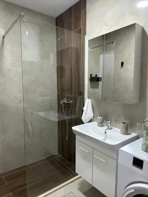a bathroom with a sink and a glass shower at Apartmani Kralj in Bar