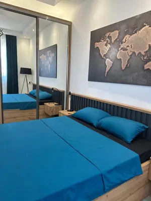 a bedroom with a blue bed and a map on the wall at Apartmani Kralj in Bar