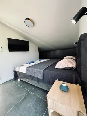 a small bedroom with a bed and a table at Adriatic Dream in Tivat