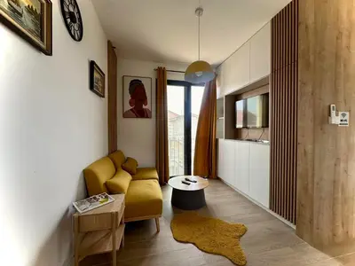 a living room with a yellow chair and a table at Adriatic Dream in Tivat