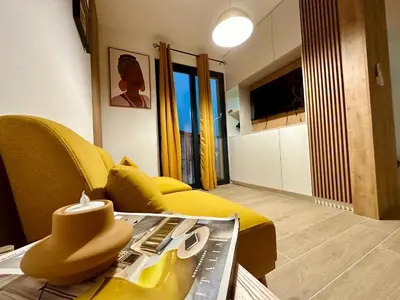 a living room with a yellow couch and a table at Adriatic Dream in Tivat