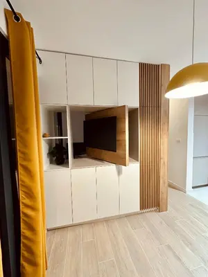 a living room with white cabinets and a flat screen tv at Adriatic Dream in Tivat