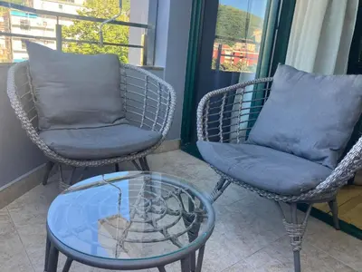 two chairs and a glass table on a porch at Stan apartman Nikola in Budva