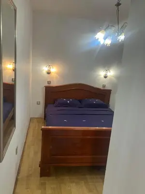 a bedroom with a bed and a mirror and lights at Stan apartman Nikola in Budva