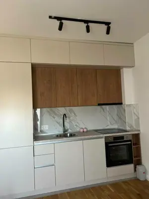 a white kitchen with a sink and a microwave at Apartman Sun in Ulcinj