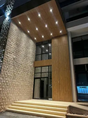 a lobby of a building with a wooden door and stairs at Apartman Sun in Ulcinj