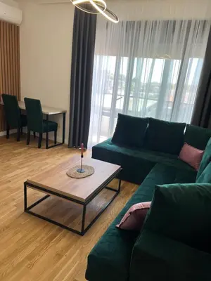 a living room with a green couch and a table at Apartman Sun in Ulcinj