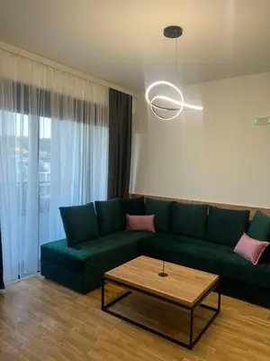 a living room with a green couch and a coffee table at Apartman Sun in Ulcinj