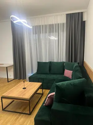a living room with a green couch and a coffee table at Apartman Sun in Ulcinj