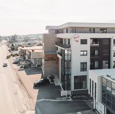 a building with a cocacola sign on it next to a street at Apartman Sun in Ulcinj