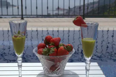 two glasses of juice and strawberries on a table at Luxury Villa Flower in Budva