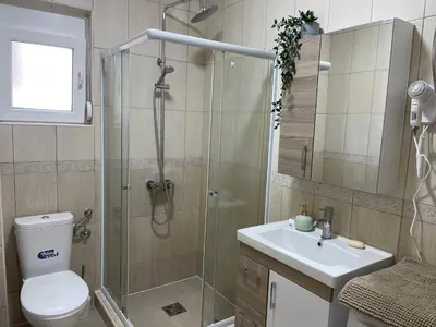 a bathroom with a shower and a toilet and a sink at Villa Sunshine in Bar