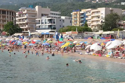 a crowd of people on a beach with umbrellas at Villa Sunshine in Bar