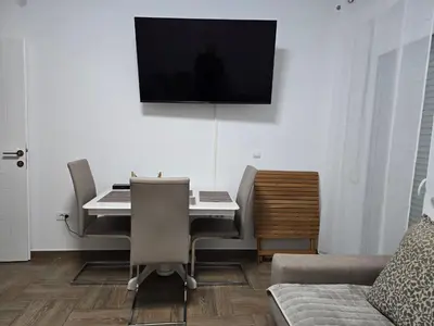 a living room with a desk and a television on the wall at Villa Sunshine in Bar