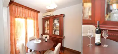 a dining room with a table and a bottle of wine at Apartment Nikolija in Dobrota