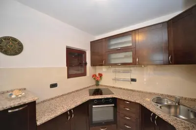 a kitchen with wooden cabinets and a sink at Apartment Nikolija in Dobrota
