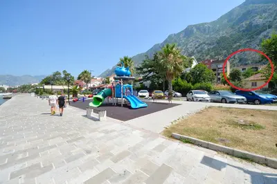 a playground with a slide in a parking lot at Apartment Nikolija in Dobrota