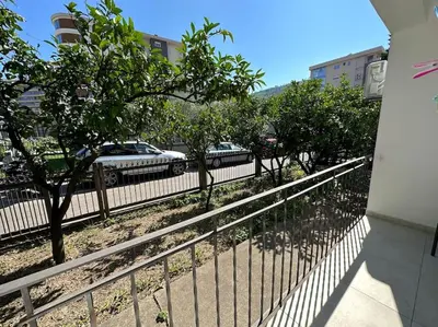 a fence in front of a street with trees and cars at Heart of the City in Budva