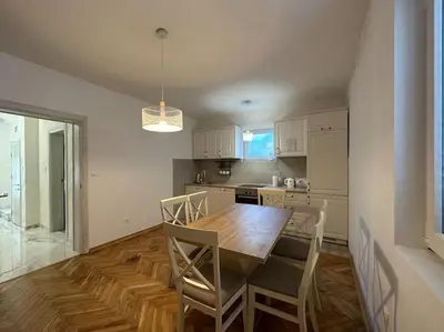 a kitchen with a wooden table and chairs in it at Heart of the City in Budva