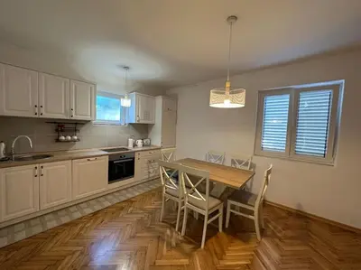 a kitchen with a wooden table and chairs in it at Heart of the City in Budva
