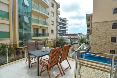 a patio with a table and chairs on a balcony at LUX Apartment TEAM JOKIC in Becici