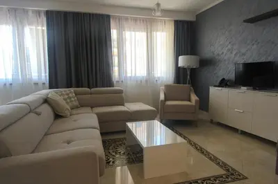 a living room with a couch and a tv at Anatolija Apartment 11 in Budva