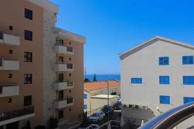 a view of two buildings and the ocean at Anatolija Apartment 11 in Budva