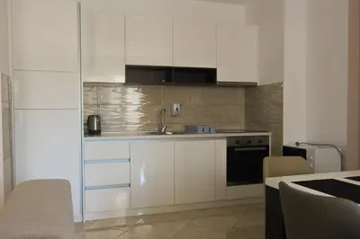 a kitchen with white cabinets and a sink at Anatolija Apartment 11 in Budva