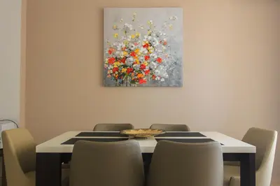 a dining room table with chairs and a painting on the wall at Anatolija Apartment 11 in Budva