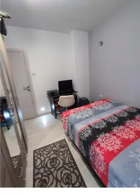 a bedroom with two beds and a desk with a computer at Nikolaj in Podgorica